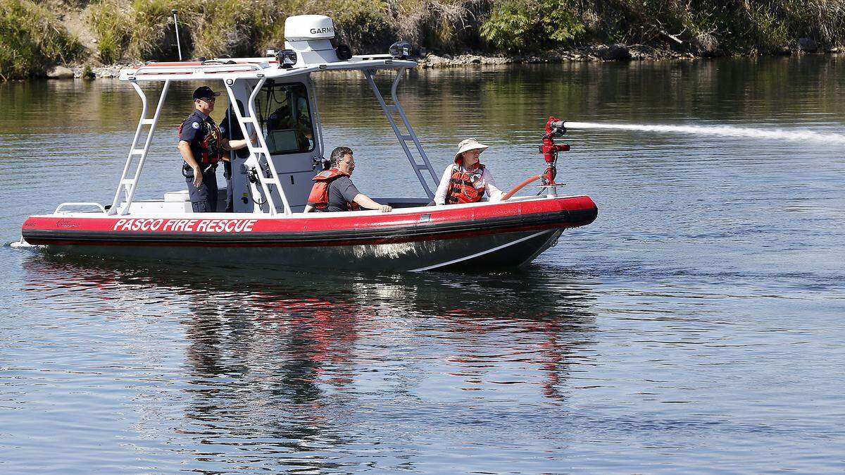 Former Councilmembers Bob Hoffman, left, and Rebecca Francik have a front row seat to a 2016 demonstration of the Pasco Fire Department’s rescue boat. The board was used to rescue a man who was swept into Columbia River from where he was fishing in Finley.