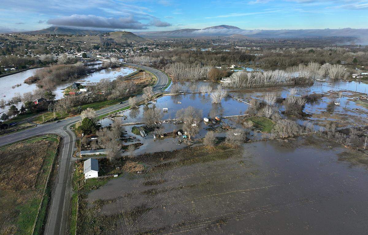 Yakima River floodwaters seep across the low-lying land Friday morning near the intersection of Kingston and Gomer Roads off Van Giesen Street in Richland.