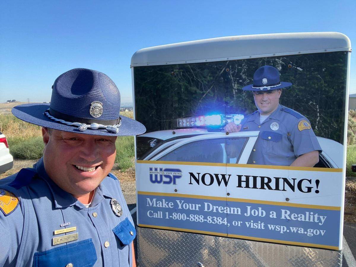 Chris Thorson stands in front of a recruiting poster featuring him.