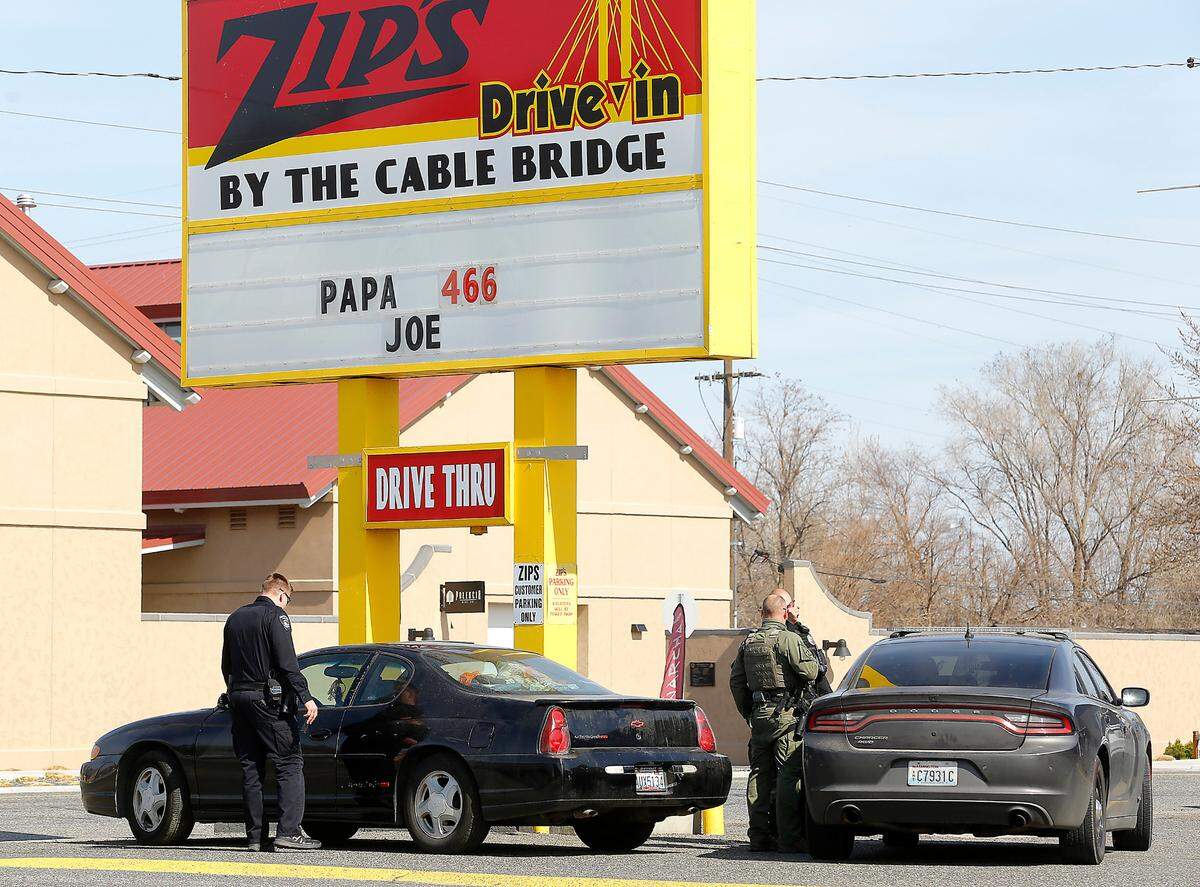 Officers prepare to tow a car after the driver was arrested Wednesday in line at the Zip’s restaurant drive-thru window after she allegedly pulling a gun.
