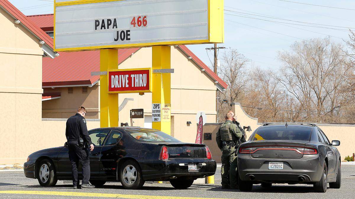 Law enforcement officers prepare to tow a car after woman was arrested in line at the Zip’s restaurant drive-thru window in Kennewick after she allegedly pulled a gun at an auto shop.