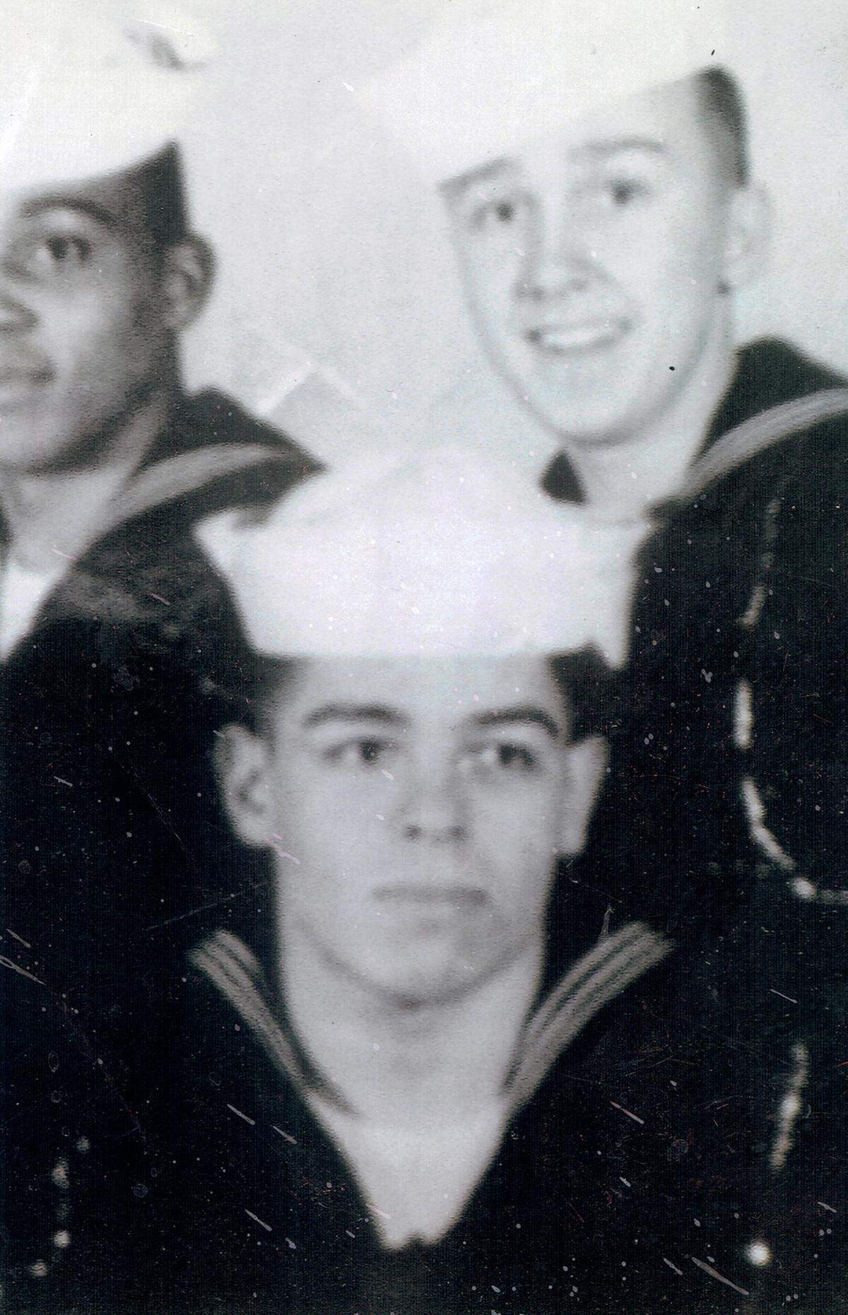 Seaman Electronics Technician Guillermo Castaneda is seated in front of boot camp buddies.