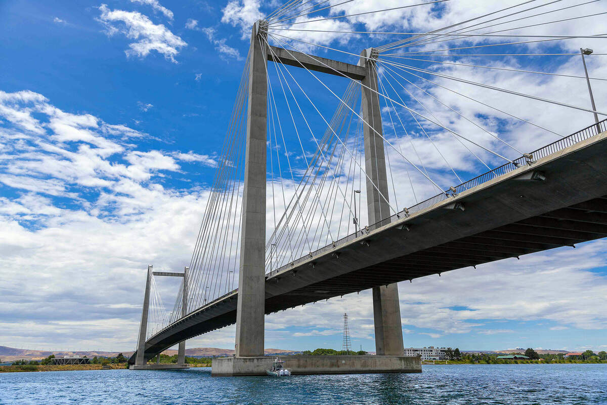 The cable bridge spans the Columbia River between Kennewick and Pasco. The high-tension power line towers can be seen on the west side near Clover Island.