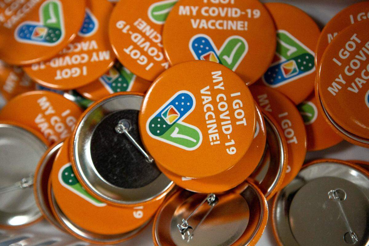 Buttons celebrating receiving the COVID-19 vaccine sit in trays on vaccination clinic tables at Tri-Cities Community Health in Pasco.