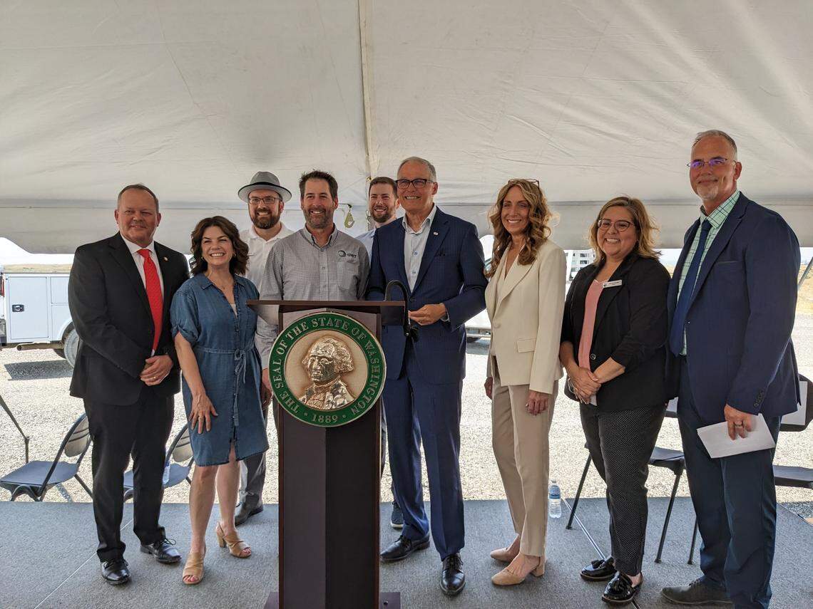 City officials and Tri-City lawmakers pose for a photo with Gov. Jay Inslee at the expansion site of the Pasco process water reuse facility in 2023.