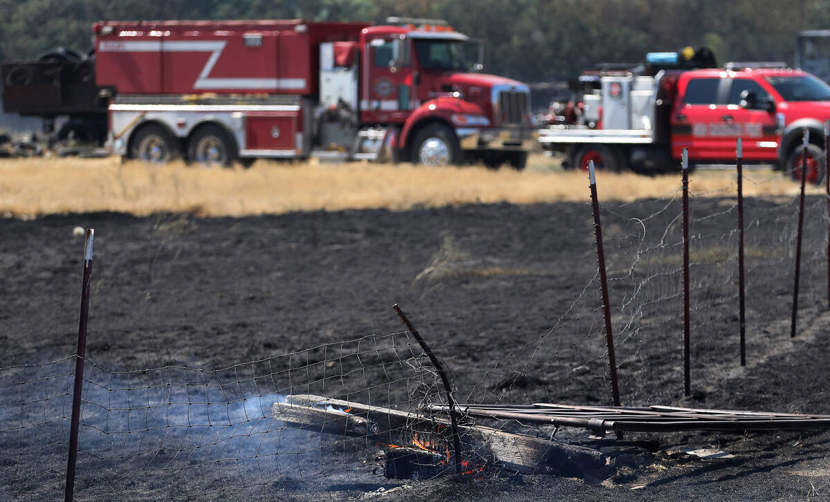 A wooden fence post smolders Monday morning at 61901 Old Inland Empire Highway where fire officials say a primary residence was consumed by Sunday's 800 acre wildfire.