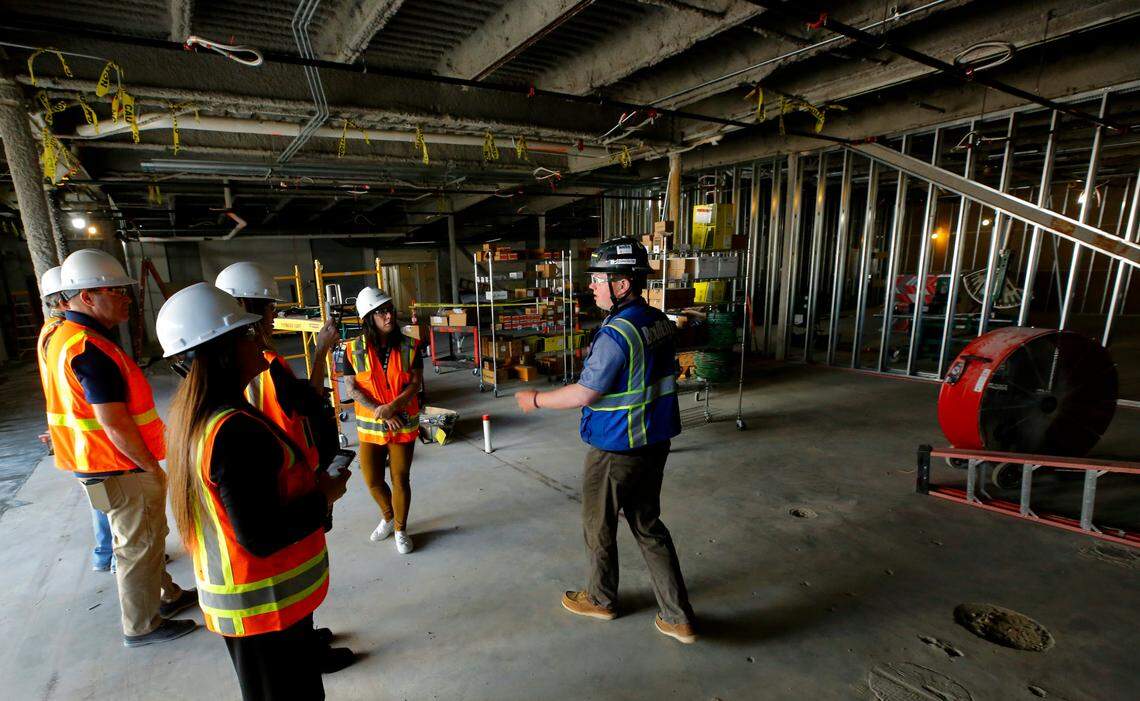 Garrett Smith, right, a senior project engineer with Bouten Construction, conducts a tour of the former Kennewick General Hospital building as construction crews work on gutting the first floor of the facility. The building renovation for the new Columbia Valley Center for Recovery facility is being designed and constructed by Bouten Construction and NAC Architecture.
