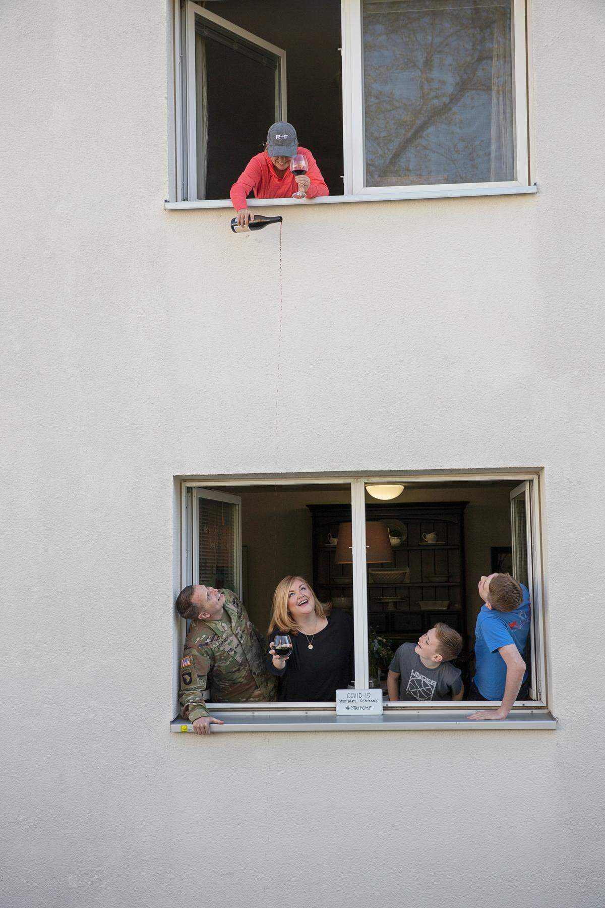 Shawn Alexander enjoys social distance “Happy Hour” with her military neighbors Travis and Lisa McIntosh (below) while their sons Drew and Will pose nearby for The Front Porch Project photo shoot.
