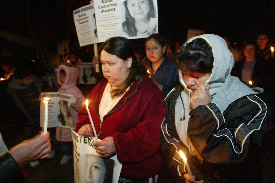 Mother Maria Juarez, center, and grandmother Ignacia Juarez carry signs and candles in honor of missing 4-­year-­old Sofia in 2003.