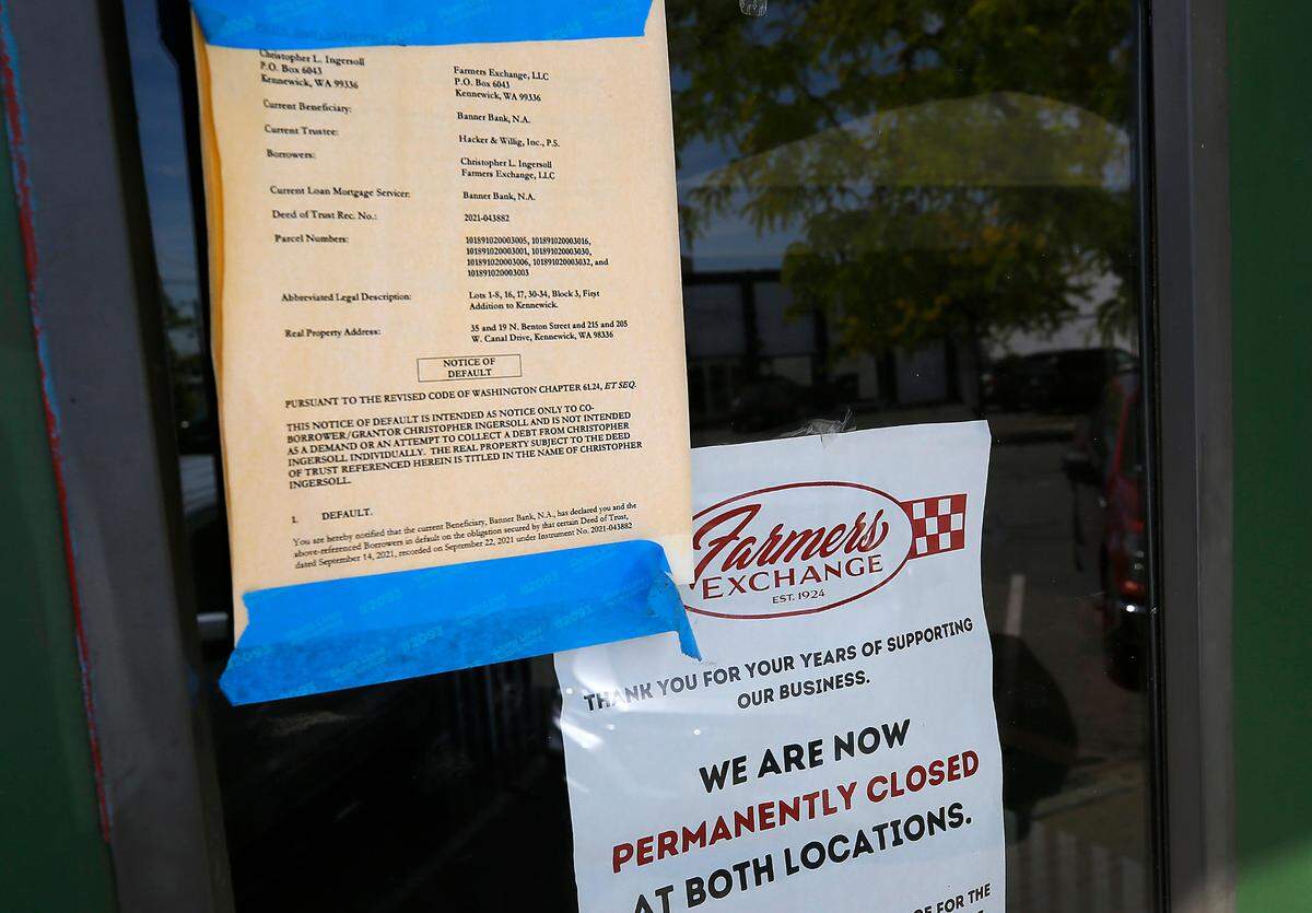 A legal notice and a sign declaring the closure of the Farmers Exchange locations in downtown Kennewick are posted on one of the building’s door.