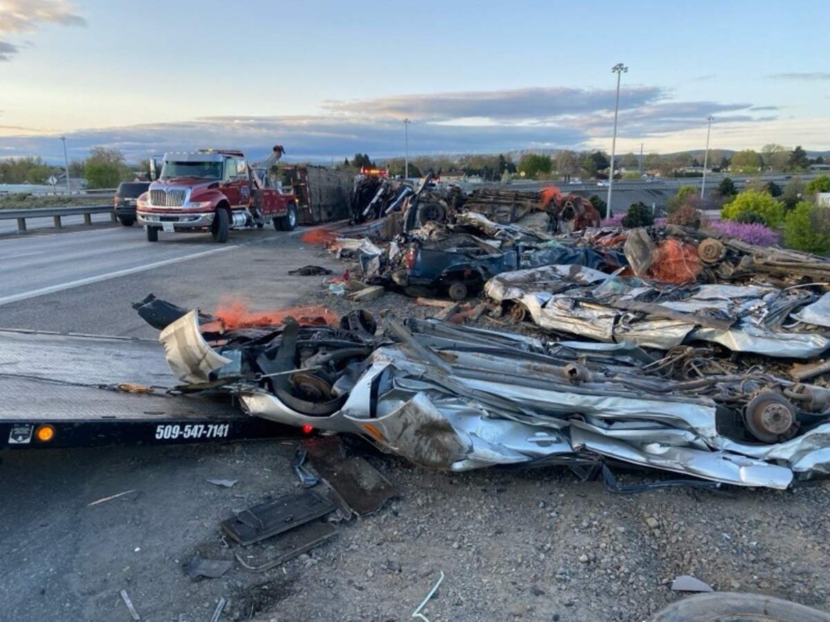 A semi tipped over and left crushed cars on the side of Highway 395 in Kennewick.