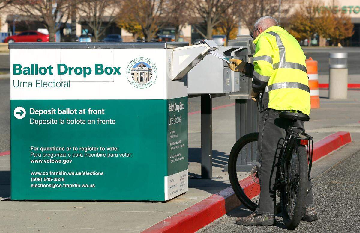 Franklin County resident Don Brown rode his bike about two mile to deliver his ballot to the drop box in the parking lot of the HAPO Center, formerly the TRAC center, off Burden Boulvevard near Road 68 in Pasco.