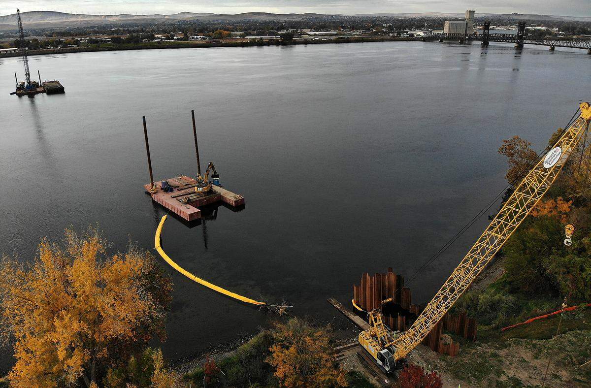 Barges, cranes and heavy equipment is staged on the Columbia River and the Pasco shoreline as part of a $5.1 million wastewater treatment plant outfall replacement project for Pasco in 2023.