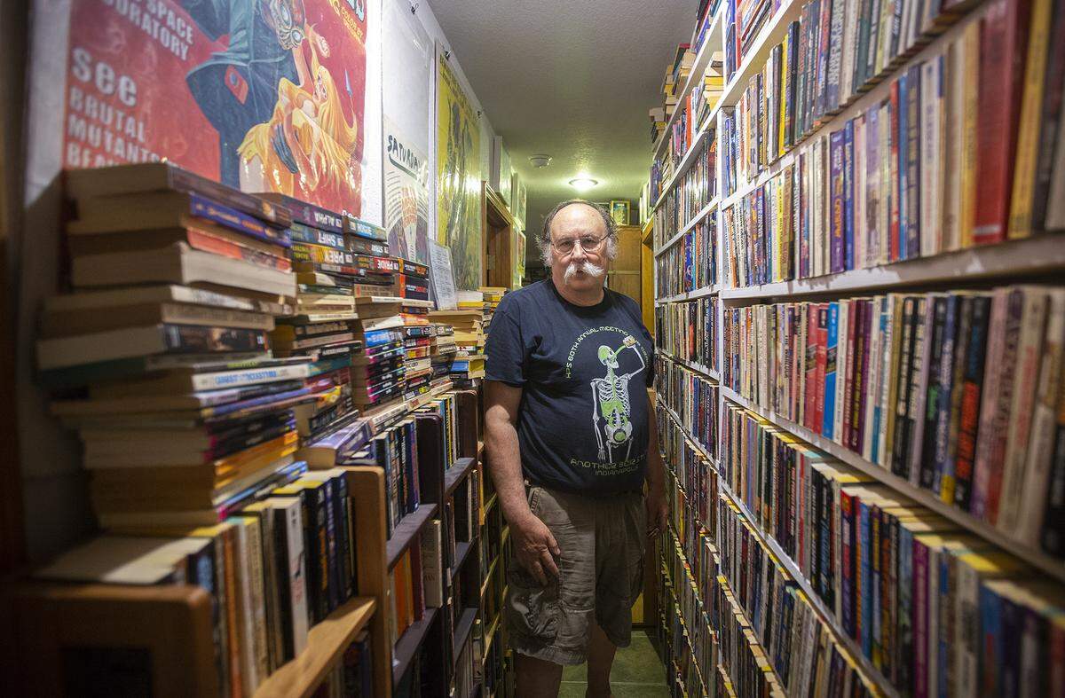 Book collector Steven Woolfolk walks through a hallway in of his home. He is building a a 6,000-square-foot bookstore in Richland near Horn Rapids to put his collection.