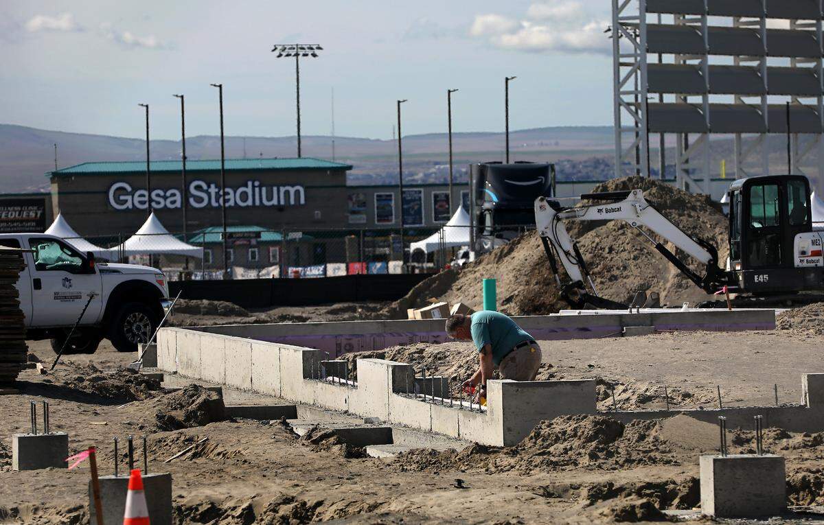 A construction worker works on the concrete foundation the $1.7 million future home of Summer’s Hub Food Truck Plaza near Gesa Stadium in Pasco.