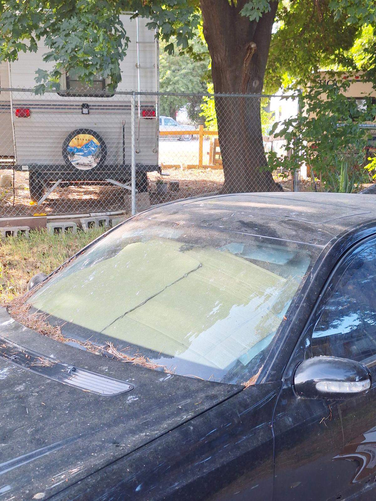 An abandoned car sits next to a lot that has seen illegal dumping in Kennewick.