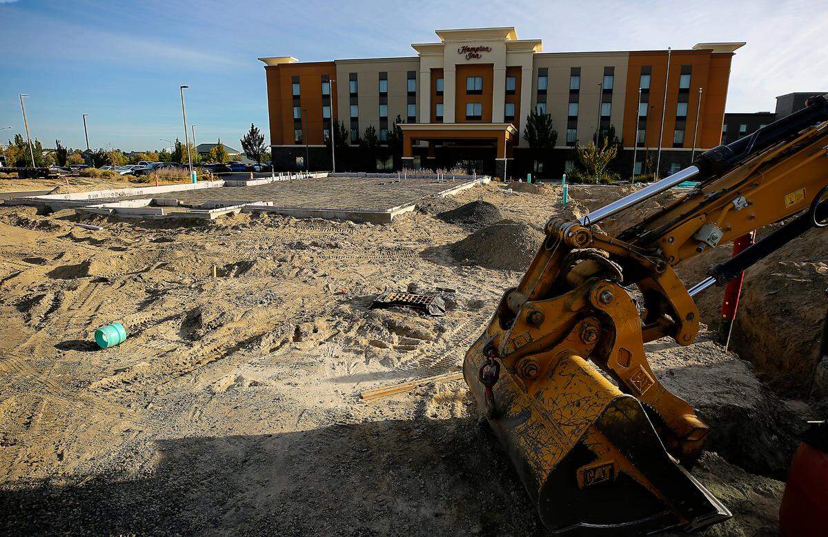 An idle backhoe sits adjacent to the concrete foundation for Moon Cafe, a new restaurant coming to 3719 Plaza Way in Kennewick’s Southridge area.