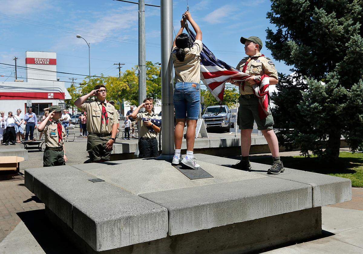 Members of the Boys Scouts of America Blue Mountain council pay fitting tribute during Monday’s formal flag retirement and disposal ceremony held by the Historic Downtown Kennewick Partnership. About 50 people attended the Flag Day event which followed protocols established by the United States Flag Code.