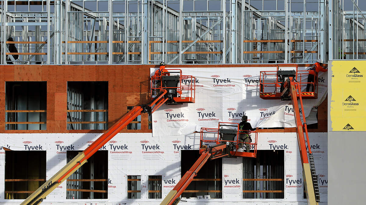 Construction workers use boom lifts to work on the exterior of the $47 million five-story AC Marriott Hotel in Kennewick.