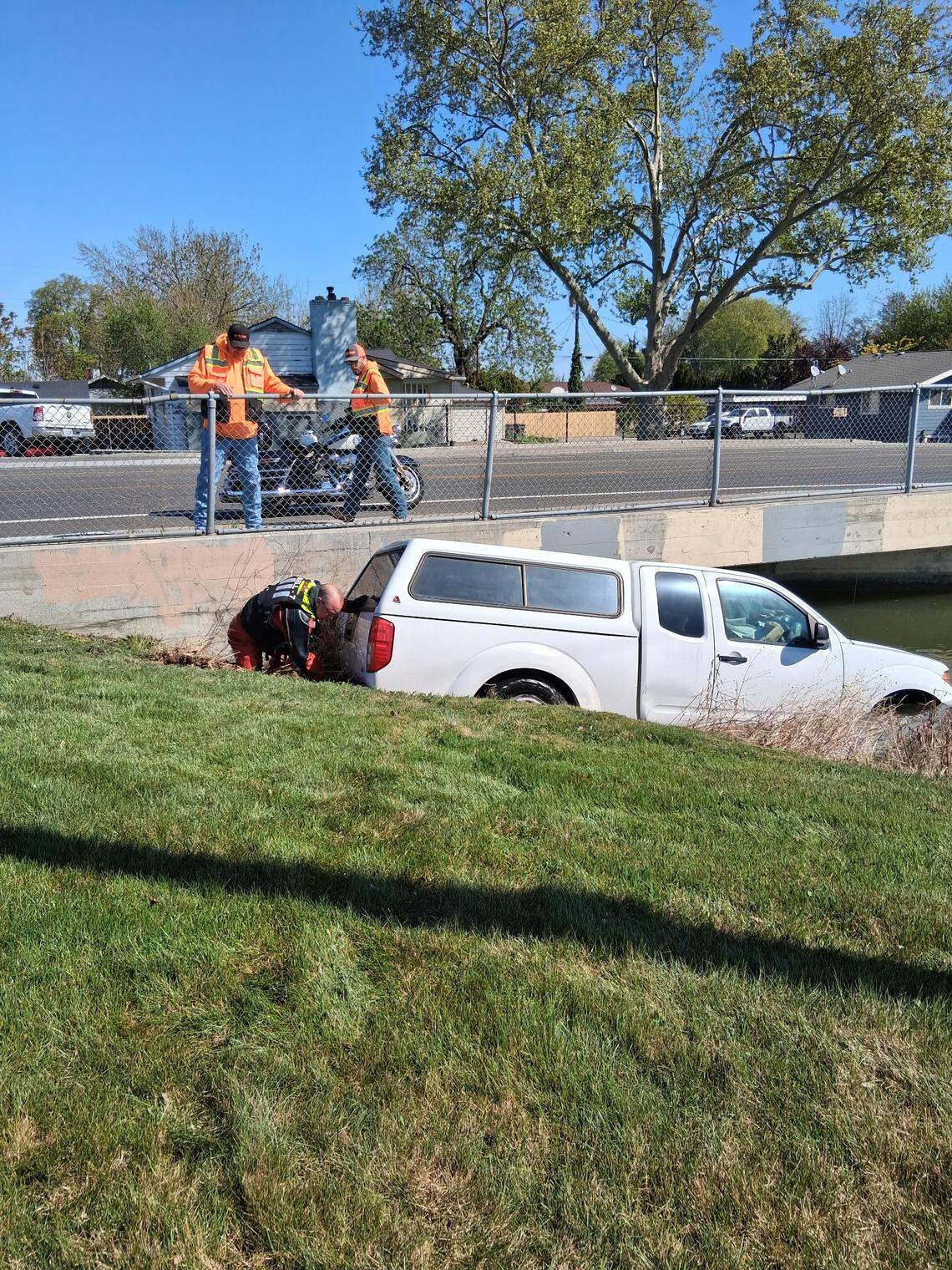 Crews work to remove a truck from a Kennewick canal after a driver experiencing a medical emergency drove into it.