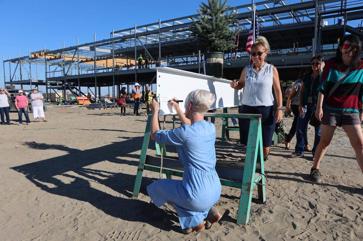 Pasco School District Superintendent Michelle Whitney signs the final structural beam before install at Sageview High School.