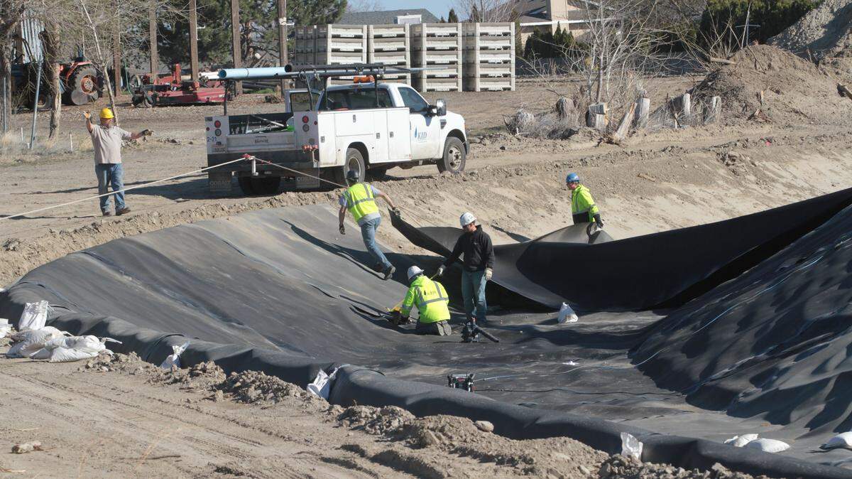 Kennewick Irrigation District employees install a flexible liner in a canal adjacent to South Ely Street near West 36th Avenue in Kennewick.