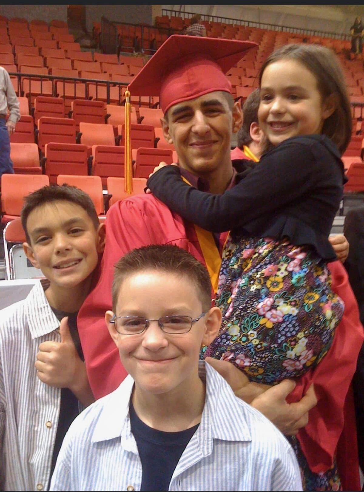 Donovan Arambul poses for a photo at his 2010 Kamiakin High School graduation with his siblings Connor, left, and Parker, center, as well as his baby sister Zoe.