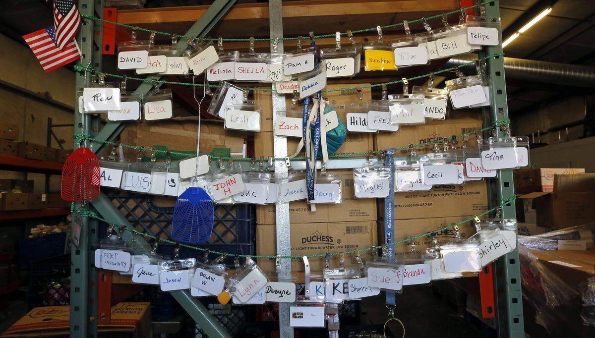 Name badges for volunteers at the Kennewick branch of the Tri-Cities Food Bank hang from a food storage rack in the back room of the bulding.
