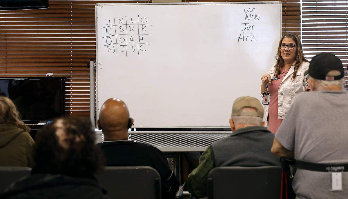 Angela Sharrer, a CNA and restorative aid, plays a word game recently with clients at Adult Day Services of the Tri-Cities in downtown Kennewick.
