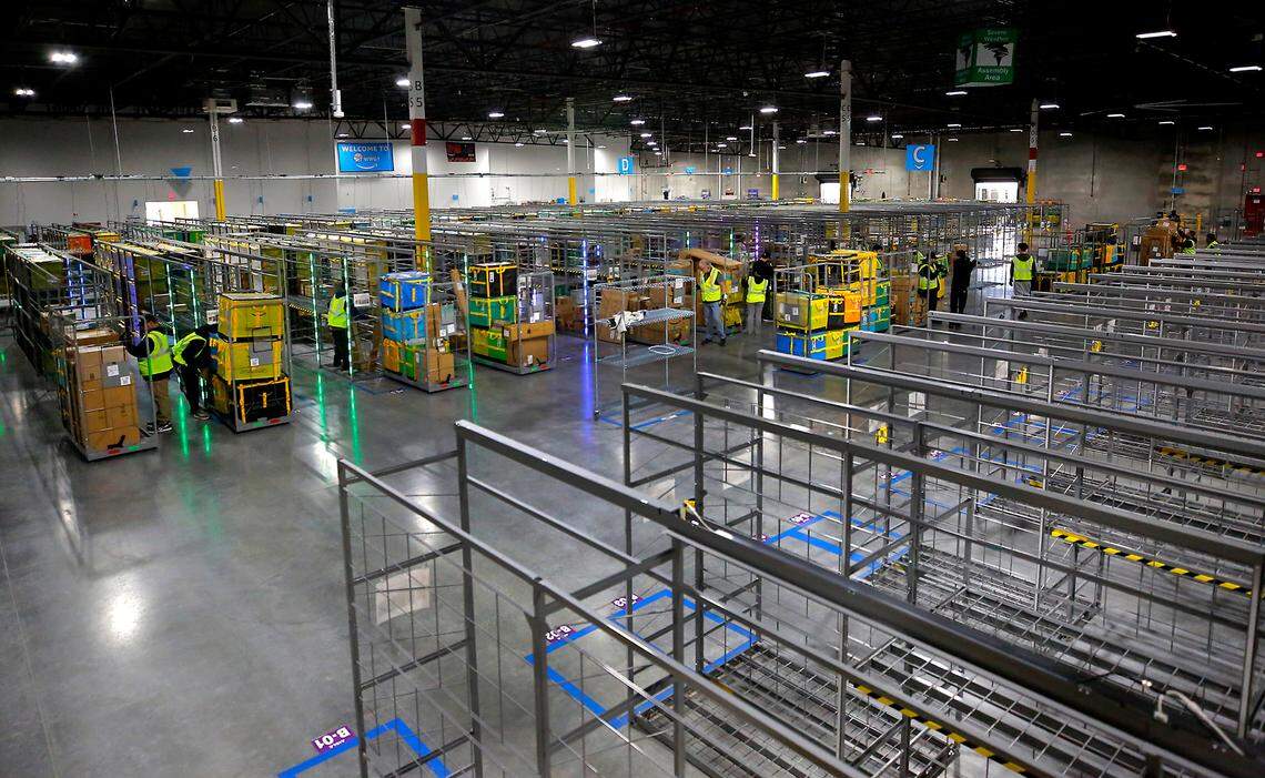 Employees at the Amazon delivery station in Pasco sort packages onto rolling carts in preparation for delivery to the Tri-Cities area. Amazon is getting ready to open its second Tri-Cities warehouse across the street.
