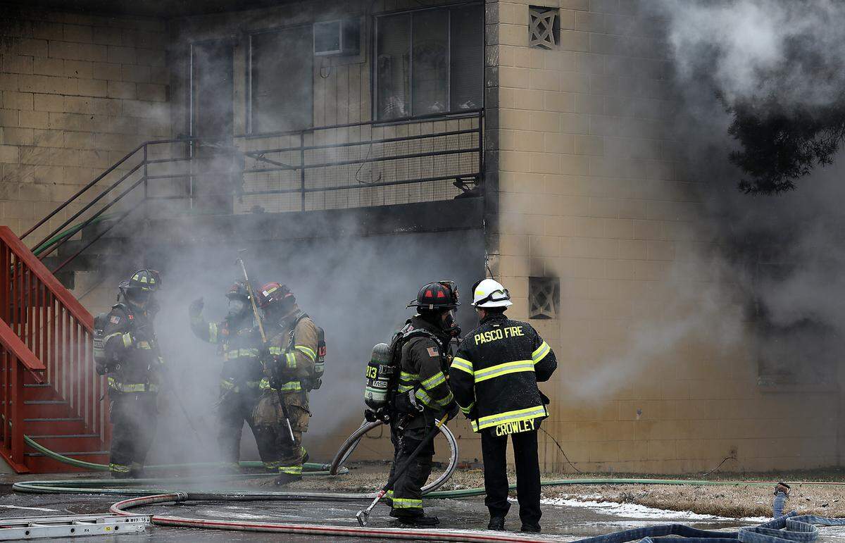 Firefighters work in bitter cold temperatures Friday extinguishing a fire at an apartment complex at 1911 W. Jay St. in Pasco.