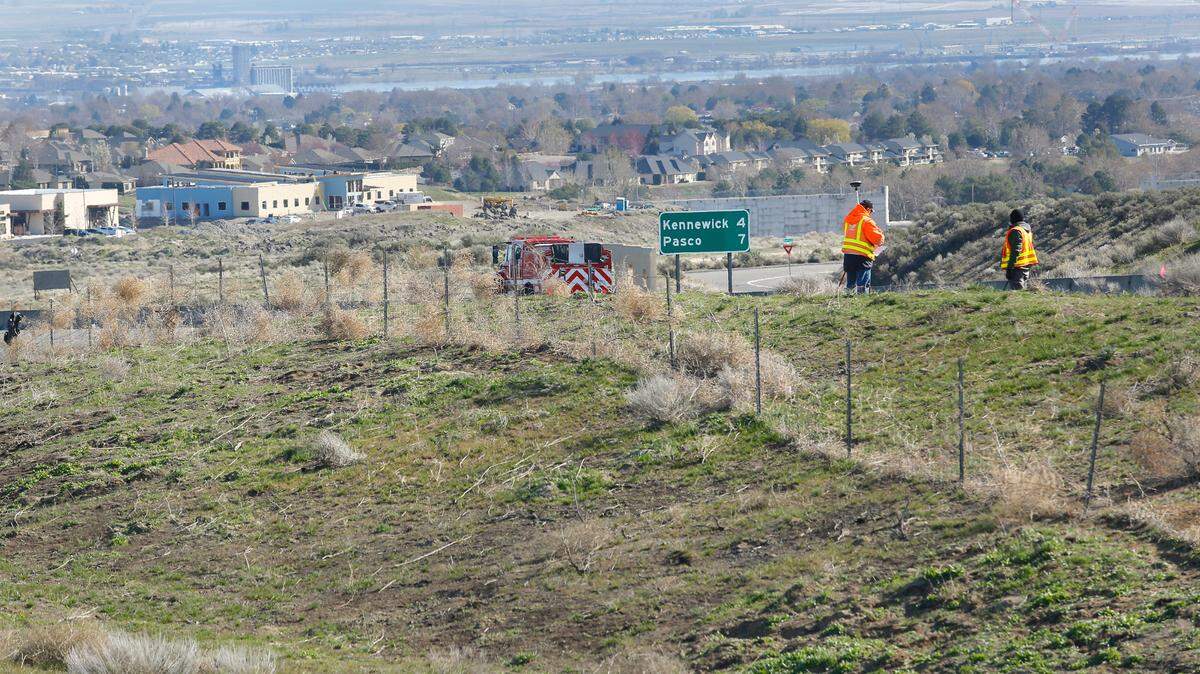 A survey crew from the Washington State Department of Transportation works near Highway 395 and Ridgeline Drive marking the ground where a new interchange is scheduled to be constructed.