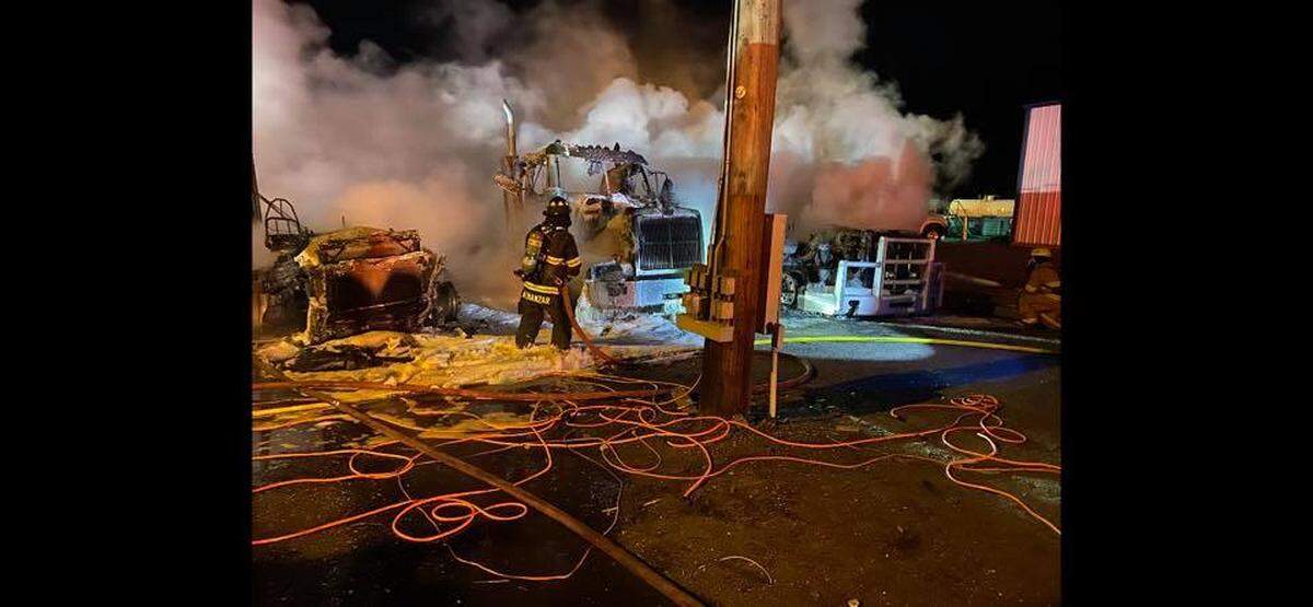 Fire crews battle a fire that destroyed seven trucks at Harms Pacific Transport.