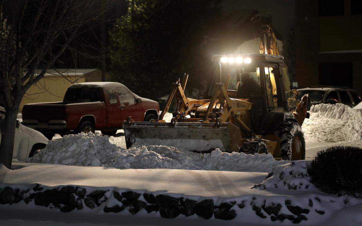 Snow removal begins before sunrise for the operator of this tractor clearing an office building parking early Friday morning following a winter storm that dropped several inches of snow across the Tri-Cities area.