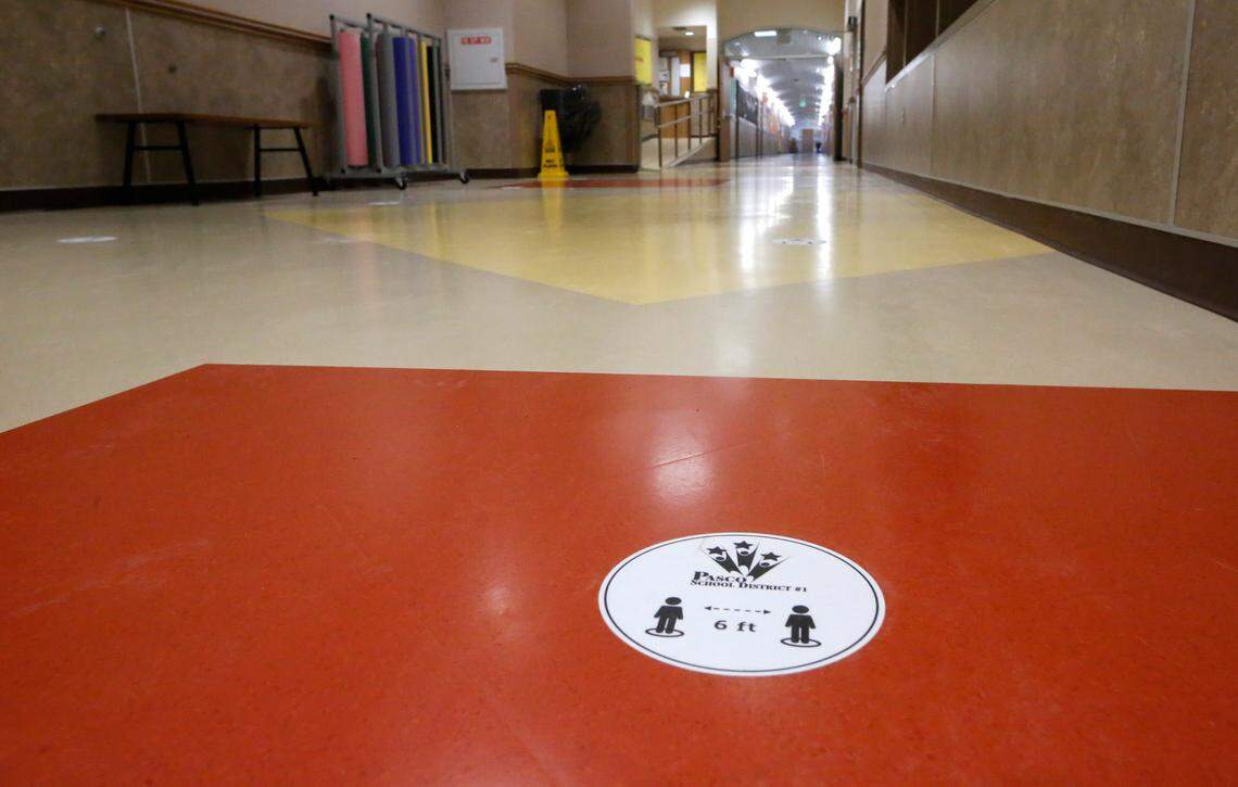 Signs on the floors remind students of social distancing protocols.