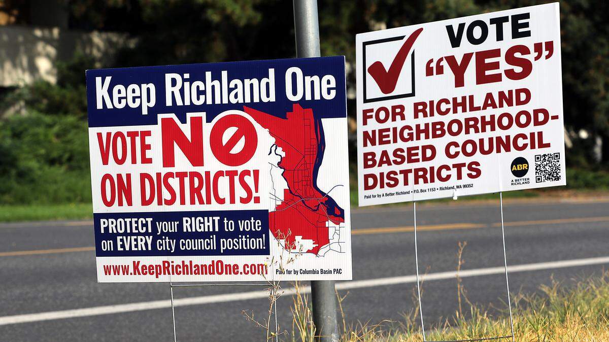 Sign of opposing views about the neighborhood-based council districts in Richland have placed side-by-side on Jadwin Avenue in Richland.