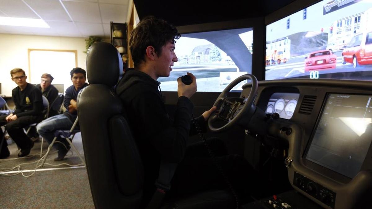 Tri-Tech Skills Center junior Levi Kaser, a student in the law enforcement class, works with a driving simulator Friday as classmates look on at the school in Kennewick. The simulator, which was installed Friday, was purchased to provide students in the law and fire programs the opportunity to get time behind the wheel in real time scenarios used by emergency employees.