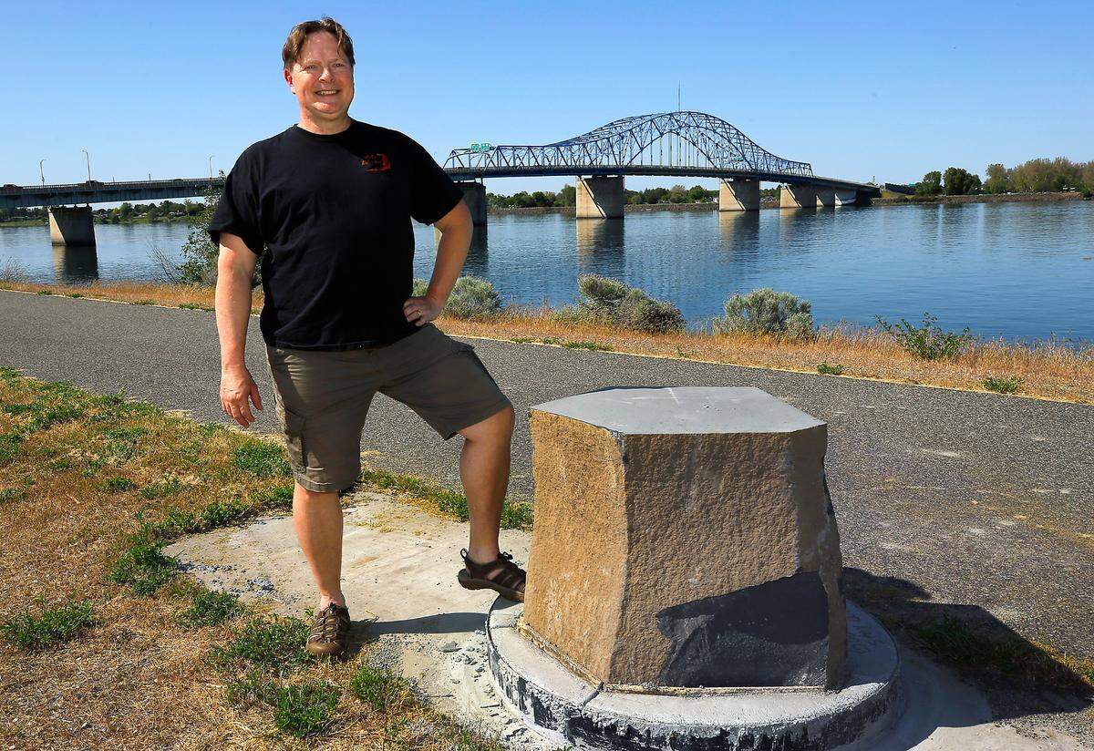 Trevor Macduff, a Richland teacher, and creator of the Hanford Reach Solar System, poses at the Jupiter orbital marker near the blue bridge in Kennewick.