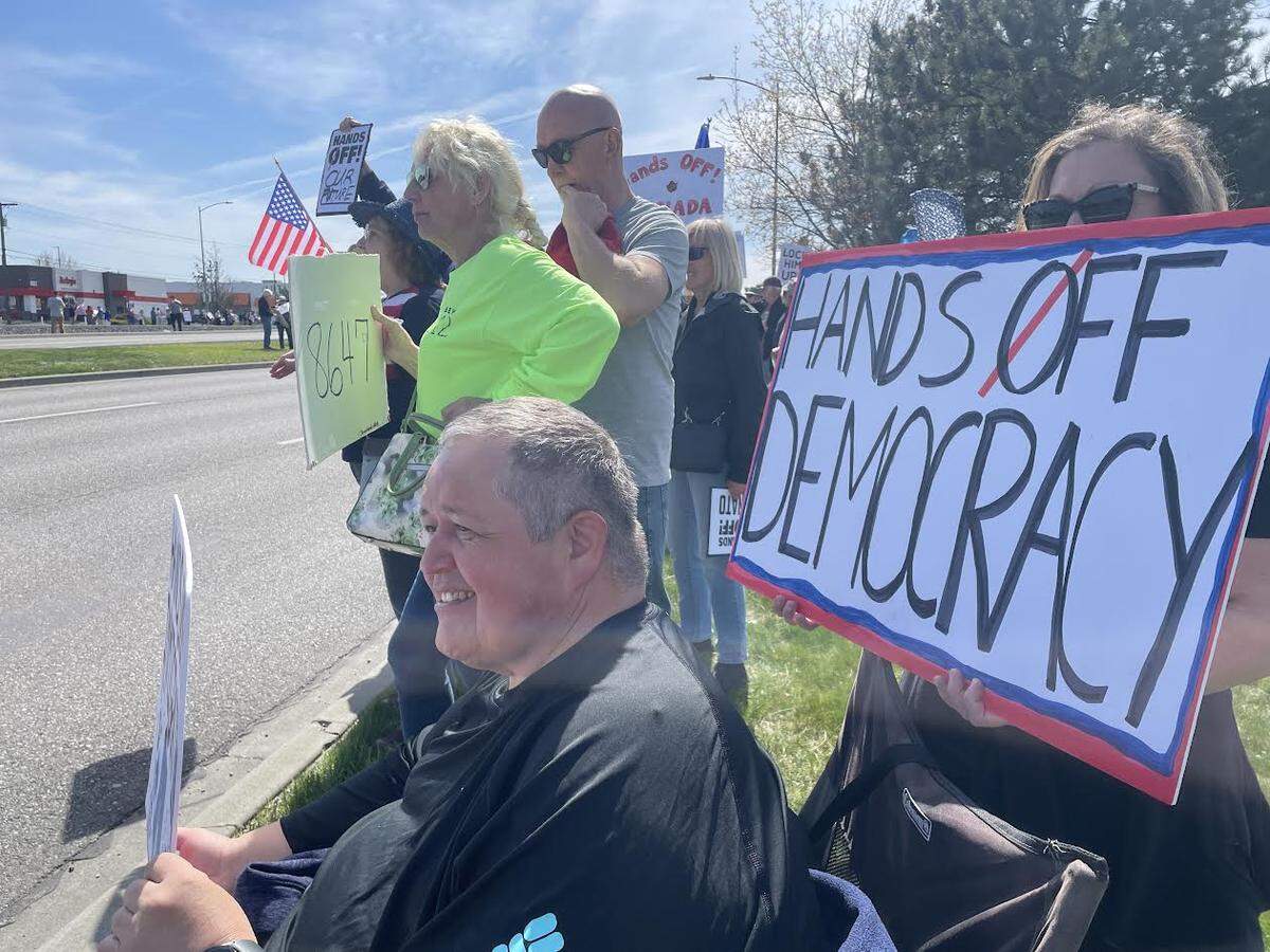 Hundreds of people lined Columbia Center Boulevard in Kennewick Saturday for a “Hands Off! Kennewick Fights Back,” to protest Trump administration policies.
