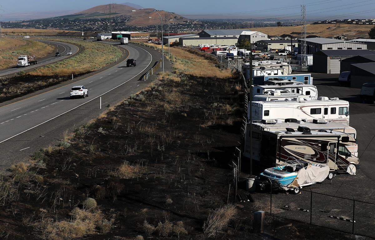 A brush fire believed to have started after a semi truck had a mechanical failure and threw sparks into the grass and spread to a nearby storage unit.