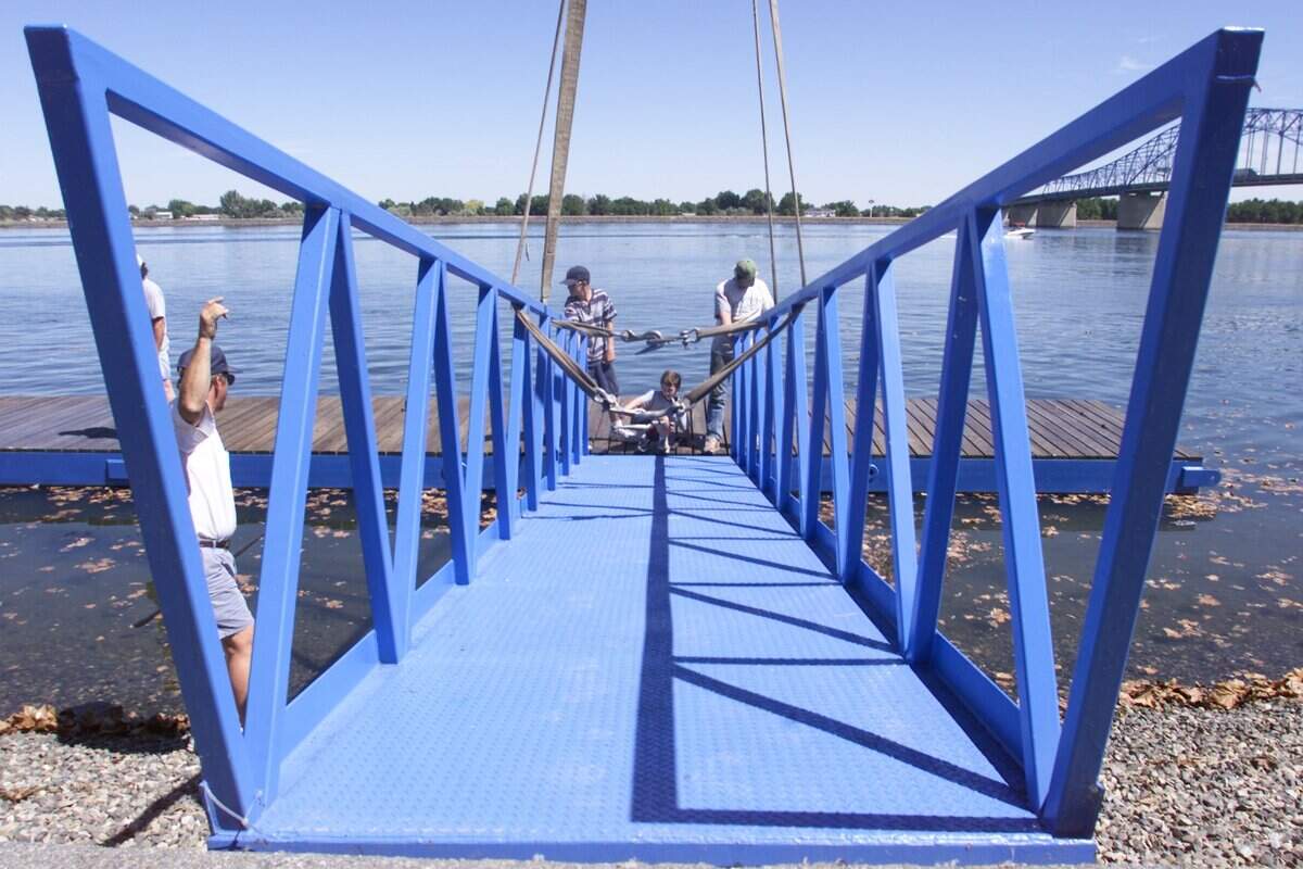 In this file photo, volunteers lift a dock ramp into place on the Columbia Park shoreline in advance of Water Follies and the Columbia Cup hydroplane races. This year, spring flooding damaged the connection points, leaving officials scrambling to ensure the docks are ready in time for this year's event.