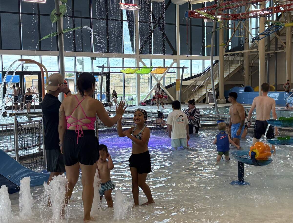 Families and children play in the zero-depth entry children’s zone inside the Pasco Aquatic Center on Saturday, June 27.