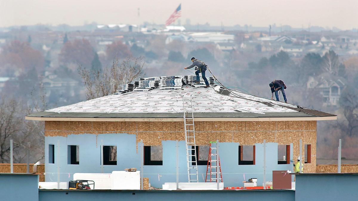Roofers work Thursday installing shingles on the circular section of a new multi-level medical office building under construction in the Spaulding Business Park area on Fowler Street in Richland off Highway 240. They have a vast view of the Richland “Y” and the Road 100 area across the Columbia River in Pasco. The general contractor is W McKay Construction of Kennewick.