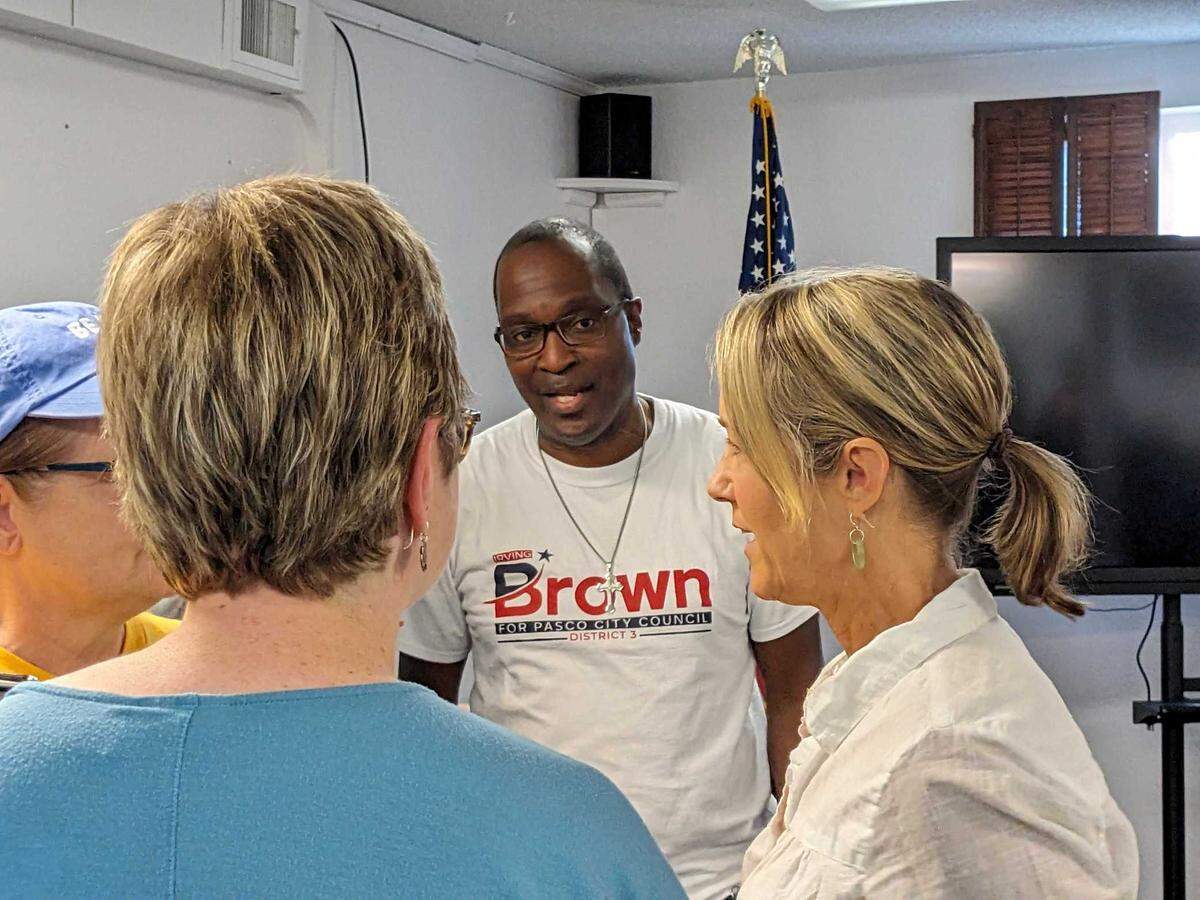 Pasco City Councilman Irving Brown Sr. speaks with constituents and attendees of a Monday evening rally to show support for him. Brown was the target of a racist message left at one of his vandalized campaign signs. He and other Pasco leaders are calling on the public to denounce the hateful message.