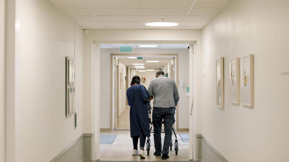 A skilled nursing center worker helps a patient.