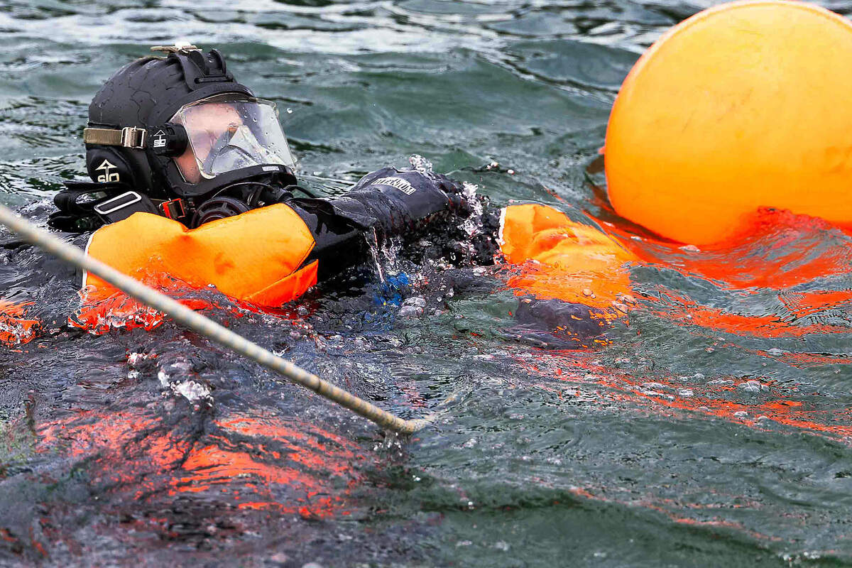 Columbia Basin Dive Rescue diver Ben Prueitt surfaces during an evidence search Sunday on the Columbia River near the cable bridge.