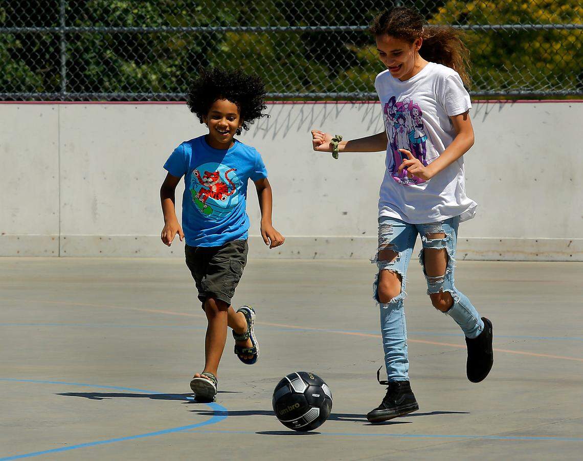 File -- Samuel Gallardo and Gaury Roque kick around a soccer ball on the concrete roller hockey rink at the Highlands Grange Park in Kennewick. 