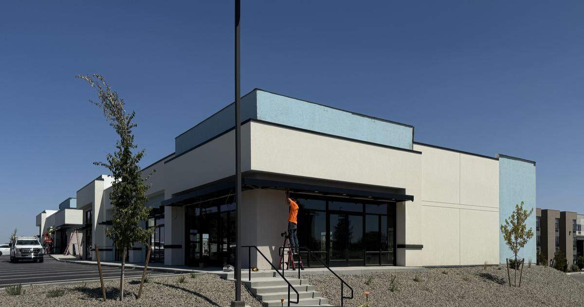 A worker puts the finishing touches on 20th Avenue Plaza, a four-building retail plaza near Columbia Basin College and the Tri-Cities Airport in Pasco. A-1 Properties, a hotel operator with projects in the area, is the developer.