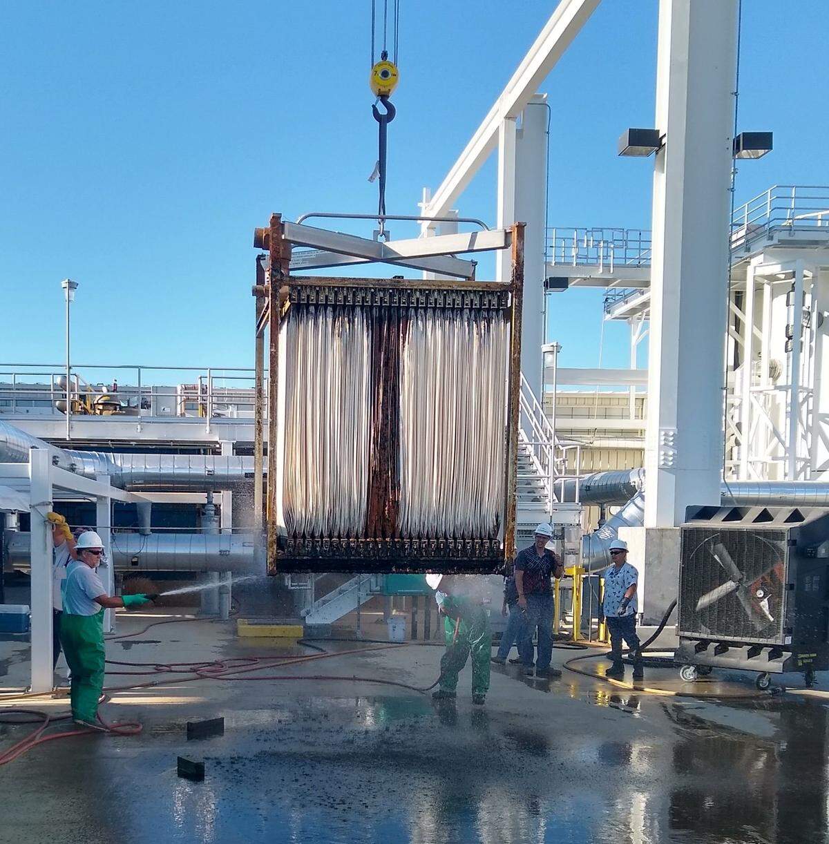 Workers clean a component used to treat groundwater at the 200 West Pump and Treat Facility at the Hanford nuclear reservation.