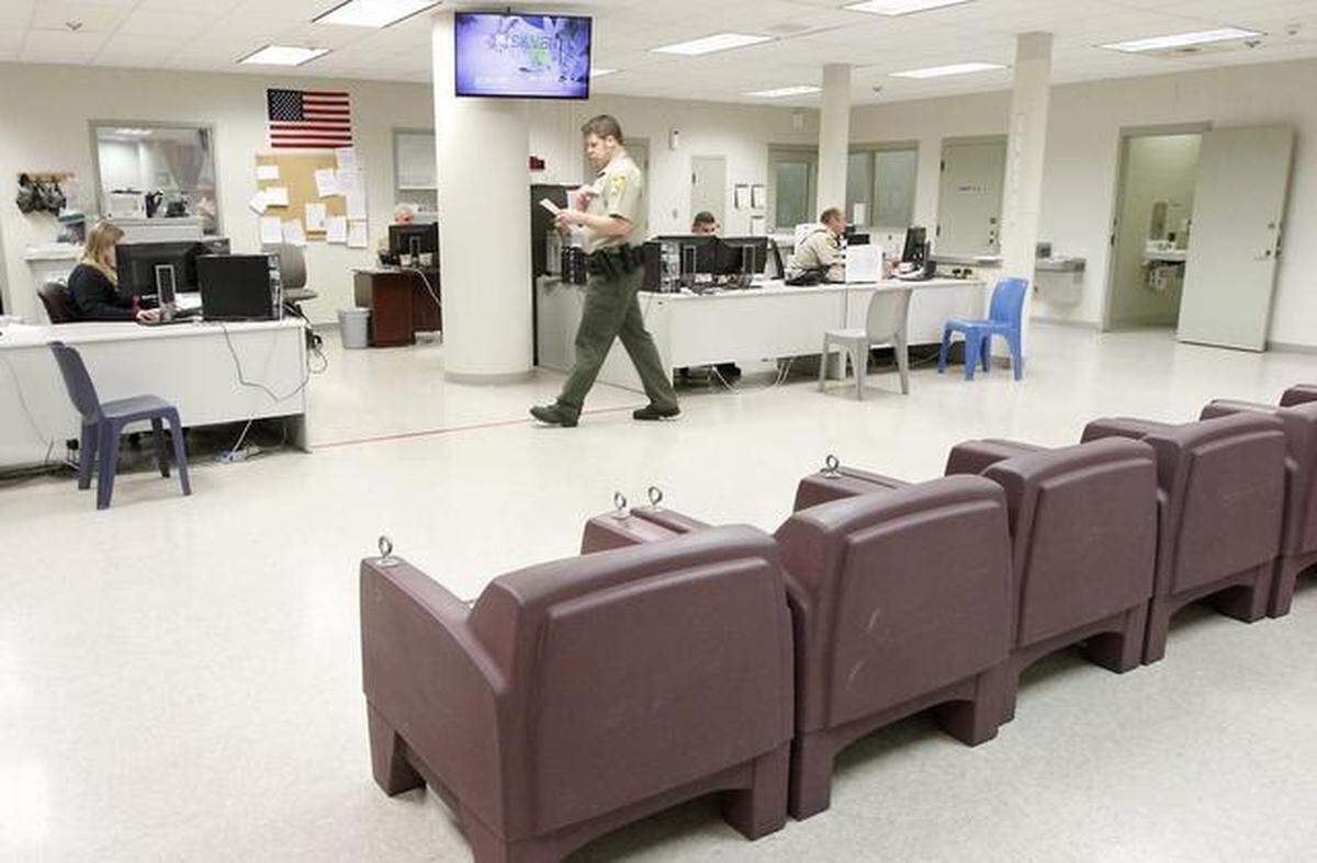 A Benton County corrections officer walks through the booking area at the Benton County jail in Kennewick.